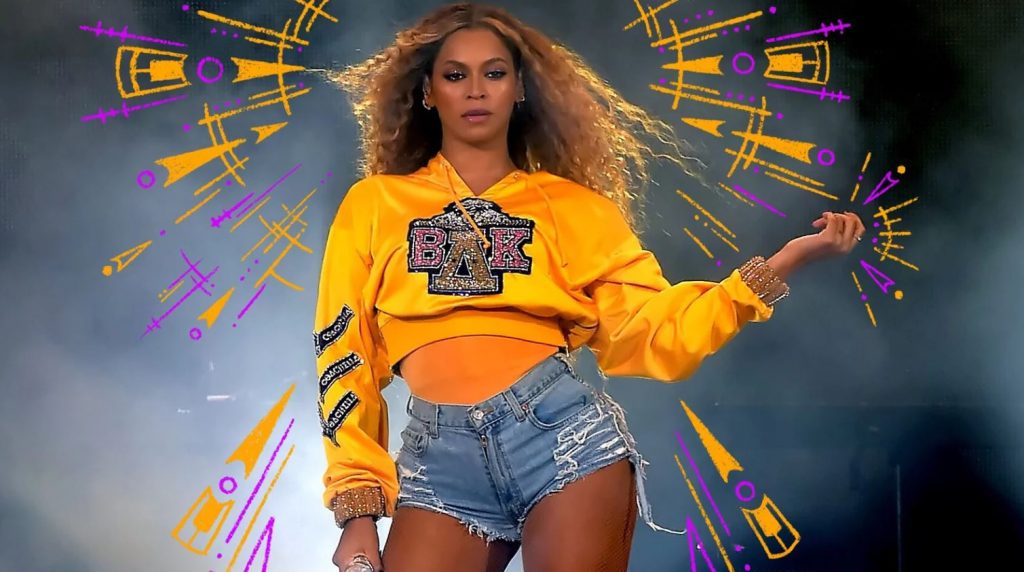 Beyonce on stage in yellow cropped sweater